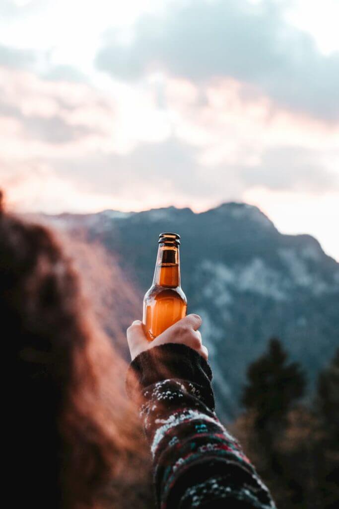 山に向かってビールを捧げる