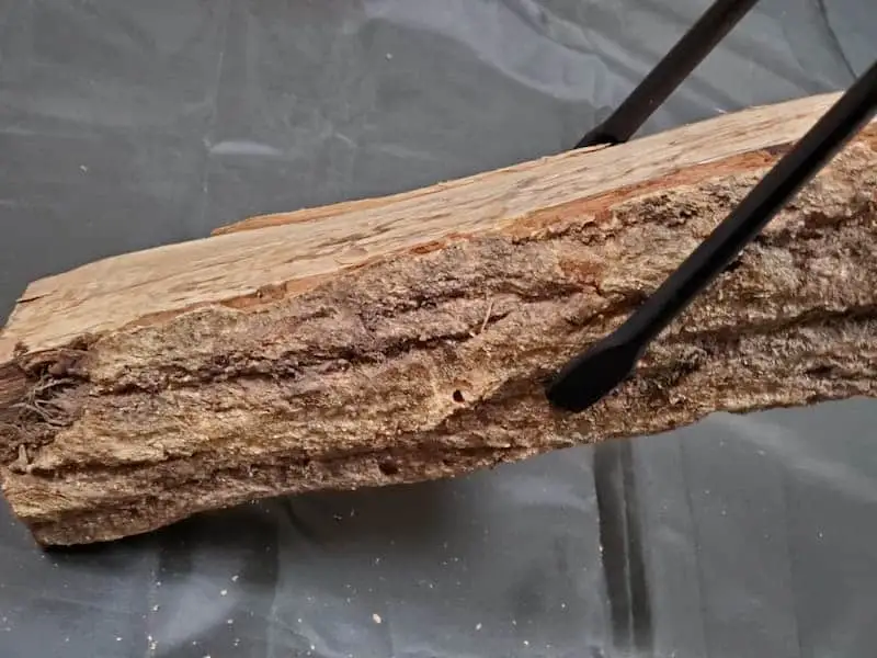 VENTLAXの「TAKIBI TONGS」で薪を持ち上げる